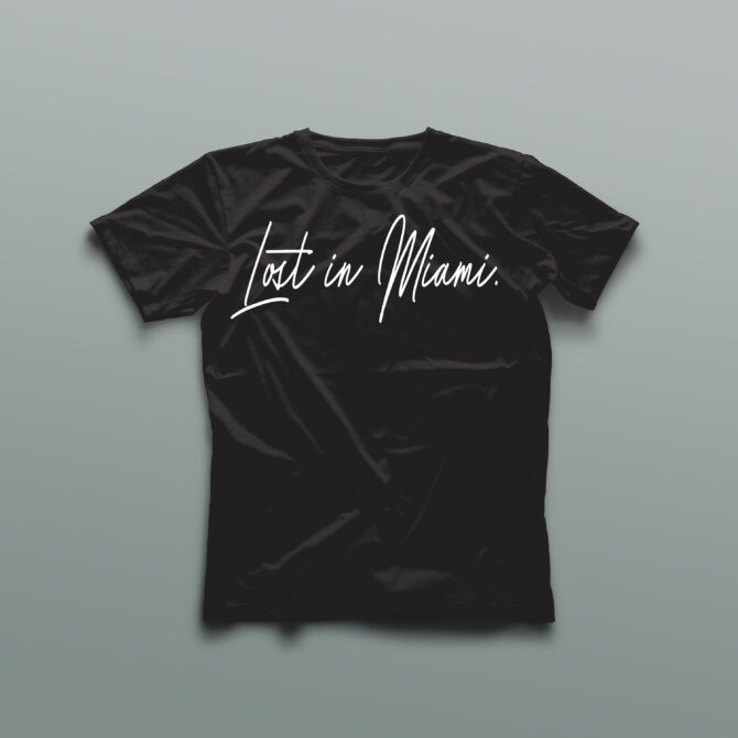 Black t-shirt with the phrase “Lost in Miami” printed across the chest in clean white handwritten script, representing a minimalist streetwear design rooted in Miami culture.