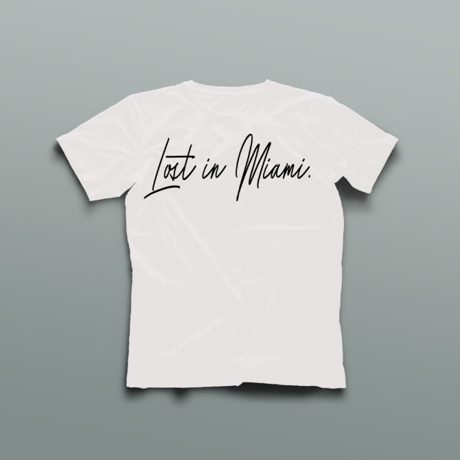 White t-shirt with the phrase “Lost in Miami” printed across the chest in bold black handwritten script, representing a minimalist streetwear statement rooted in Miami culture.